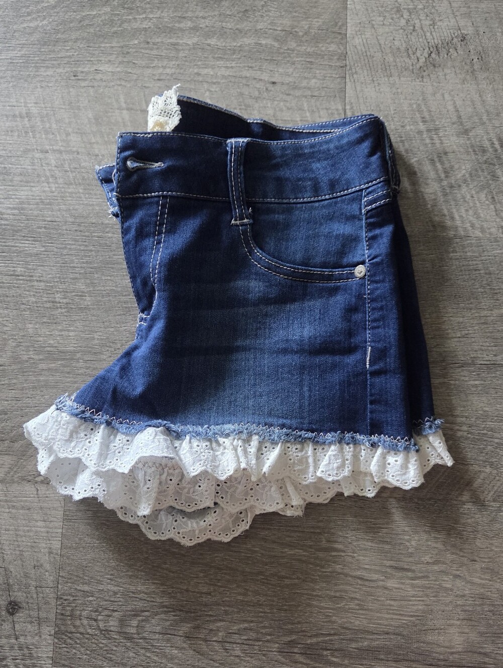 Altar'd State Dark Blue Denim Shorts with White Eyelet Lace Trim.